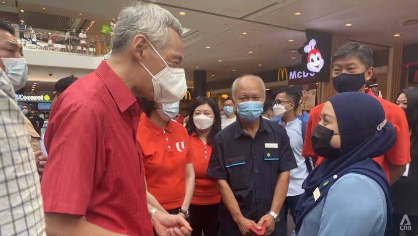Prime Minister Lee Hsien Loong speaking to customer service officer Irnawati Rohen at Jurong Point on the eve of Chinese New Year, Jan 31, 2021.