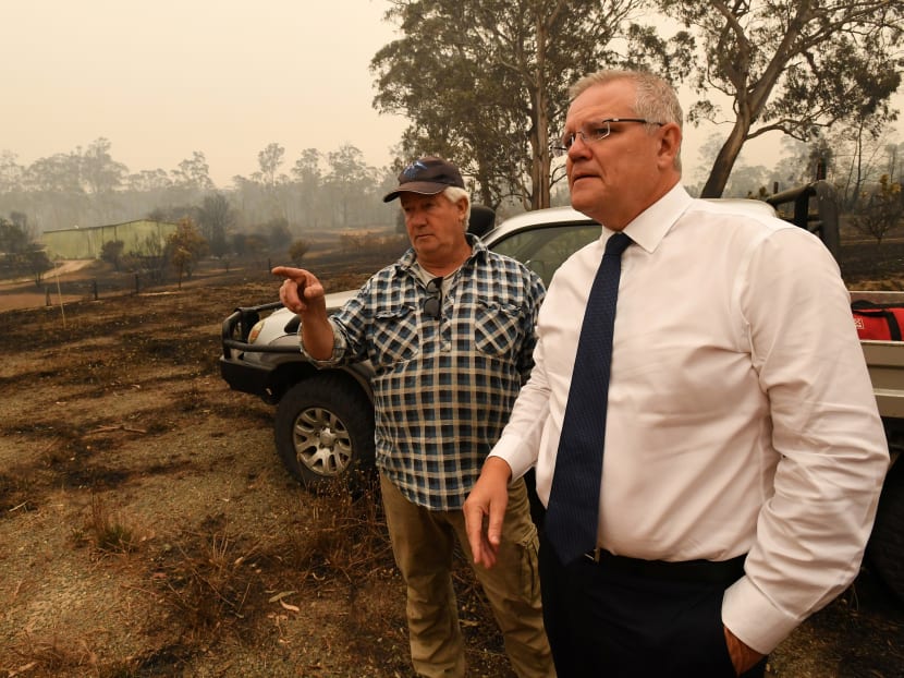 Australia's Prime Minister Scott Morrison (right) tours a farm that suffered fire damage in Sarsfield, Victoria, Australia, Jan 3, 2020.