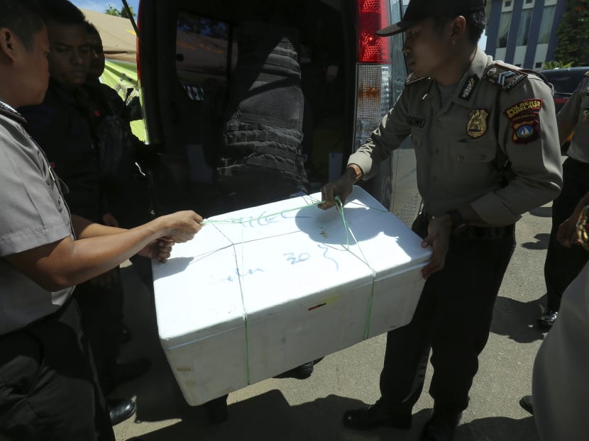 Police carry a box containing remains of victims from a plane that went missing in Batam on Dec 4, 2016. Photo: AFP