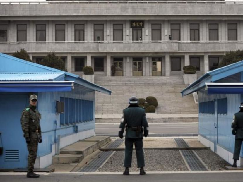 A North Korean soldier stands on top of the stairs, as South Korean soldiers stand guard below at the truce village of Panmunjom in the demilitarised zone dividing the two Koreas, in Paju March 12, 2014. Photo: Reuters