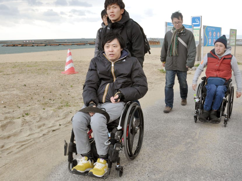 Mr Shinya Furunaka (front) and Mr Shunsuke Kido (back)
assessing the suitability of Suma Beach in Kobe, Japan, for wheelchair users. Photo: Kyodo