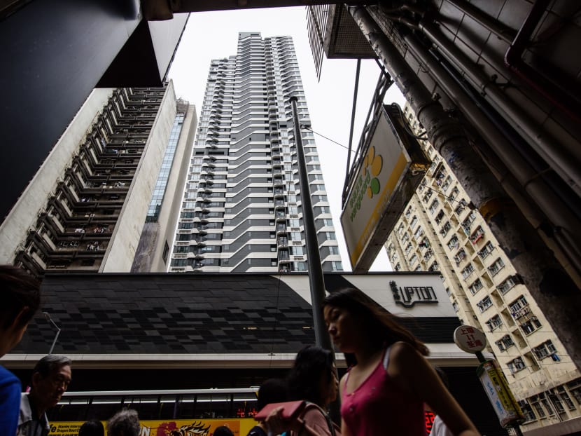 Pedestrians walking on the street below the Upton residential building  in Hong Kong.  AFP file photo