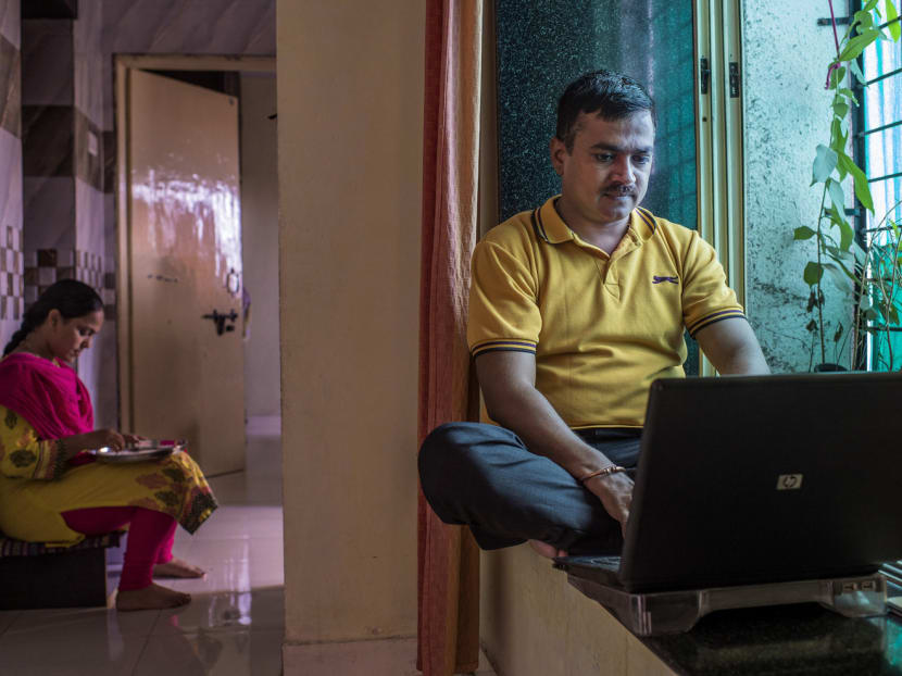Mr Sudhakar Choudhari, who recently lost his job at Tech Mahindra, searching for job listings in his one-bedroom apartment in Pune, India. Artificial intelligence, automation and big data are raising fears of widespread layoffs in India’s S$208 billion industry which employs about four million people. Photo: The New York Times