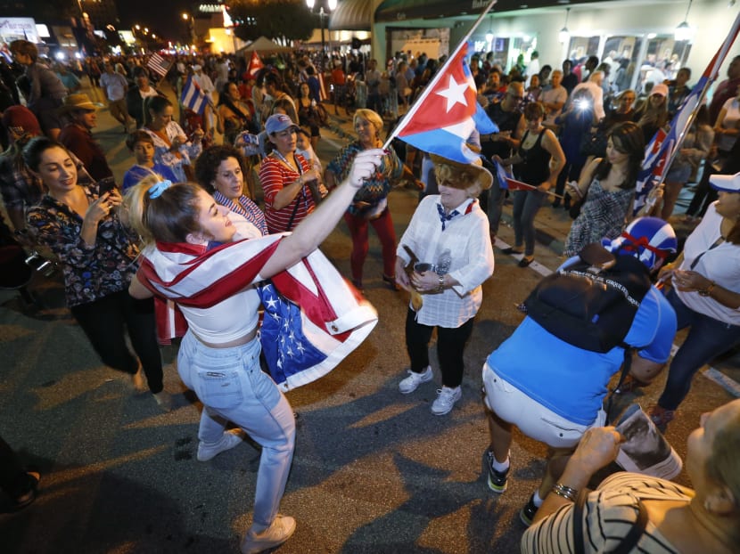 Members of the Cuban community dance in the street as they react to the death of Fidel Castro, Saturday, Nov. 26, 2016, in front of the Versailles Restaurant in the Little Havana neighborhood of Miami. Photo: AP