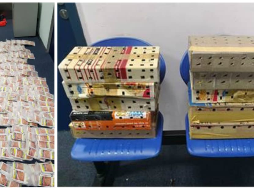 121 live birds (R), hidden in boxes, and 4,500 sachets of chewing tobacco were seized from tour bus at Woodlands Checkpoint on Monday morning. Photo: ICA