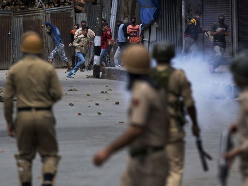 Kashmiri protesters facing Indian policemen during a curfew in Srinagar. Indian government troops backed by local police have been maintaining a tight security lockdown throughout the region, but that has not stopped the protests against Indian rule. Photo: AP