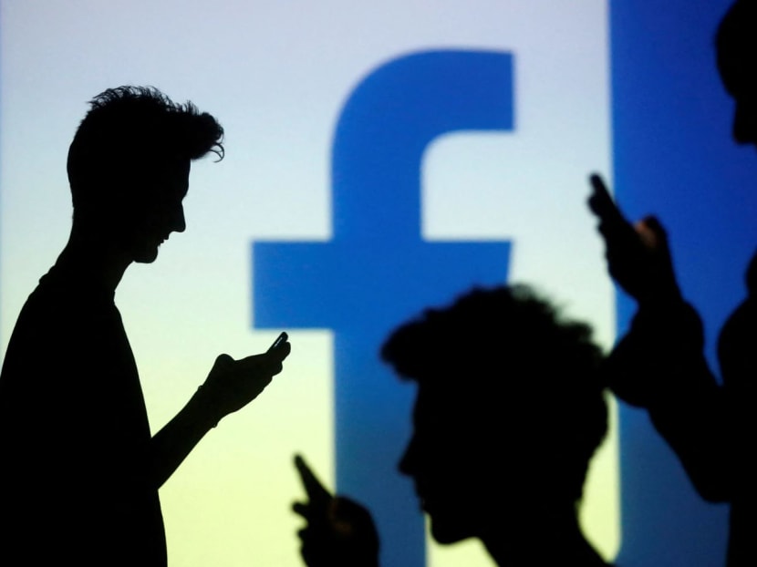 People are silhouetted as they pose with mobile devices in front of a screen projected with a Facebook logo, in this picture illustration. People are silhouetted as they pose with mobile devices in front of a screen projected with a Facebook logo, in this picture illustration.