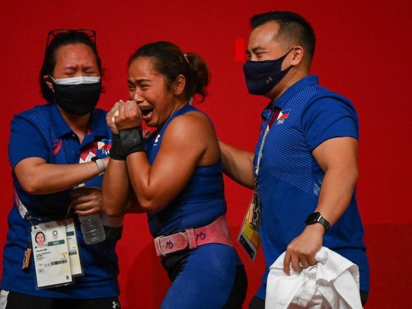 Hidilyn Diaz (centre) celebrates with her team after winning gold at the Tokyo 2020 Olympics.