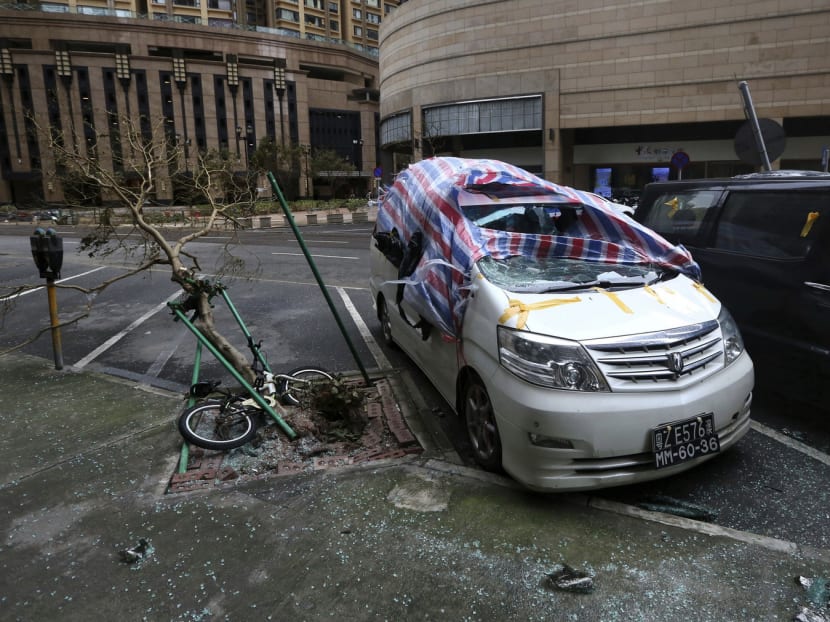 Damaged cars and a fallen tree caused by tropical storm Pakhar in Macau, yesterday. In Hong Kong, a total of 236 trees weakened by Wednesday’s typhoon were brought down by the latest storm. Photo: AP