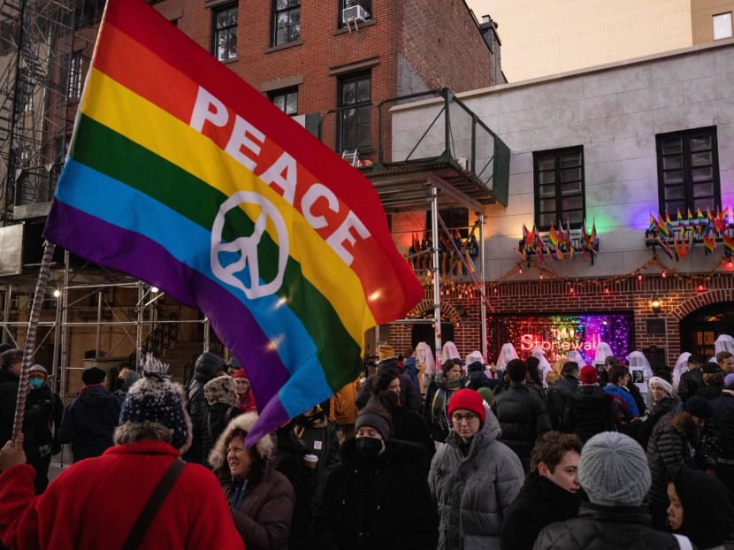A person holds a rainbow flag during a vigil on Trans Day of Remembrance at The Stonewall Inn in New York City on Nov 20, 2022.
