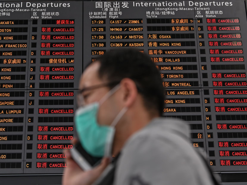 A man wearing a facemask speaks on a cellphone at Shanghai Pudong International Airport in Shanghai on March 26, 2020.