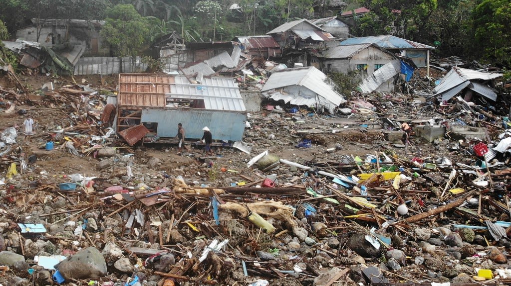 An aerial view shows residents walking past destroyed houses in the village of Pilar, Abuyog town, Leyte province on April 14, 2022, days after a landslide struck the village due to heavy rains at the height of tropical Storm Megi. An aerial view shows residents walking past destroyed houses in the village of Pilar, Abuyog town, Leyte province on April 14, 2022, days after a landslide struck the village due to heavy rains at the height of tropical Storm Megi.