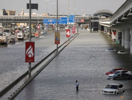 FILE PHOTO: A person stands surrounded by flood water caused by heavy rains, in Dubai, United Arab Emirates, April 17, 2024. REUTERS/Amr Alfiky/File Photo