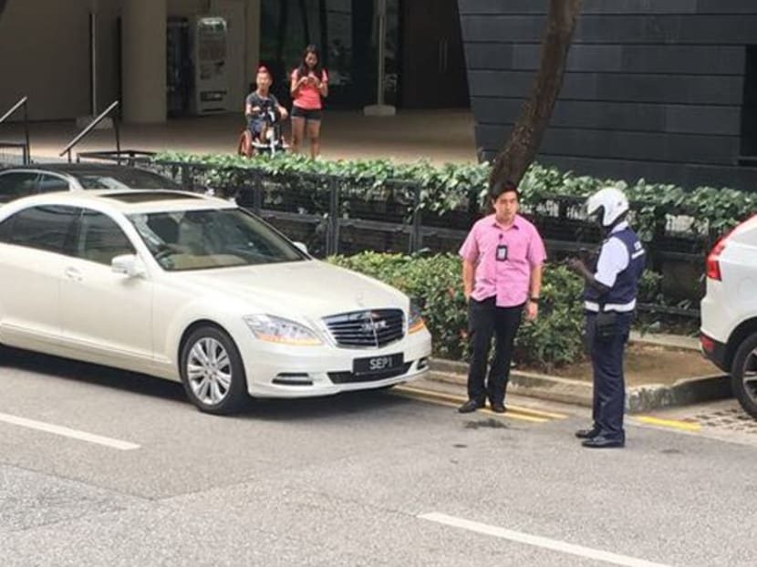In a widely circulated photo on social media and messaging apps, a Land Transport Authority (LTA) officer can be seen talking to the driver of one of the cars, with the special number place "SEP1". Photo: Social Media