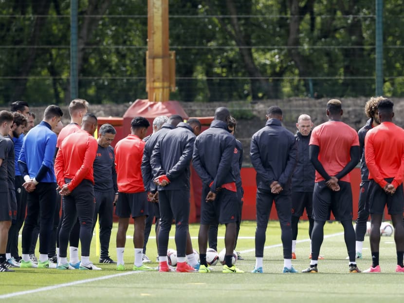 Manchester United's Wayne Rooney stands alongside teammates for a minutes silence in memory of the victims of the Manchester terror attack during the training session at the AON Training Complex in Carrington, ahead of the Europa League Final against Ajax. Photo: Martin Rickett/PA Wire via AP