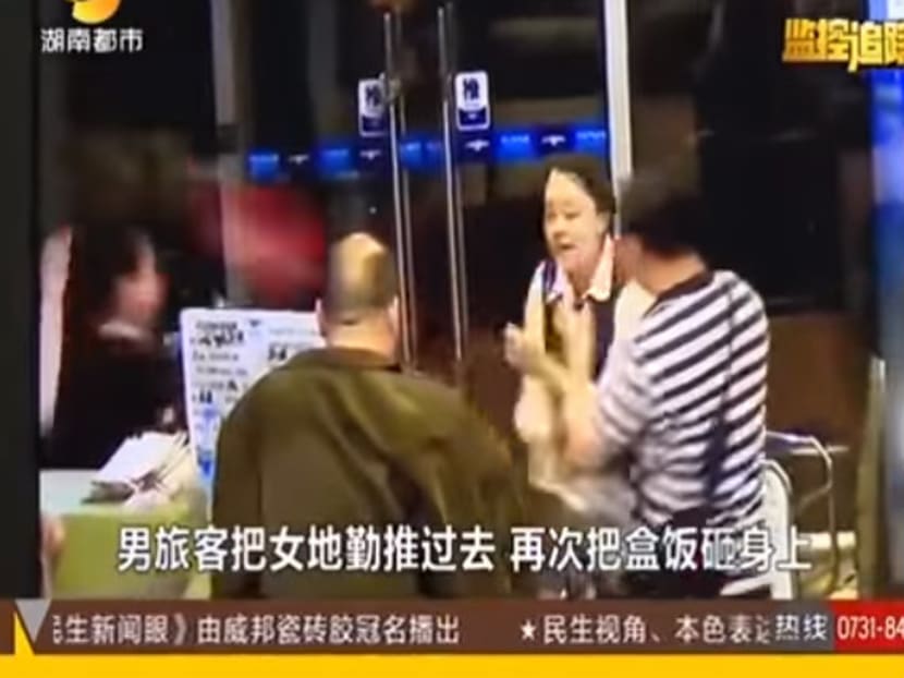 A screenshot of an airline passenger throwing food at the ground staff. Photo: People's Daily 人民日报 / YouTube