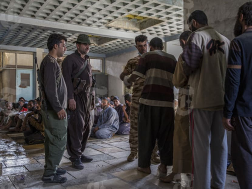 Men suspected of being Islamic State fighters are searched at a security screening center near Kirkuk, Iraq. More than 1,000 militants turned themselves in after the latest in a string of humiliating defeats in Iraq and Syria. For ISIS, whose fighters pledge to choose suicide over surrender, the mass surrenders have been a turning point. Photo: The New York Times