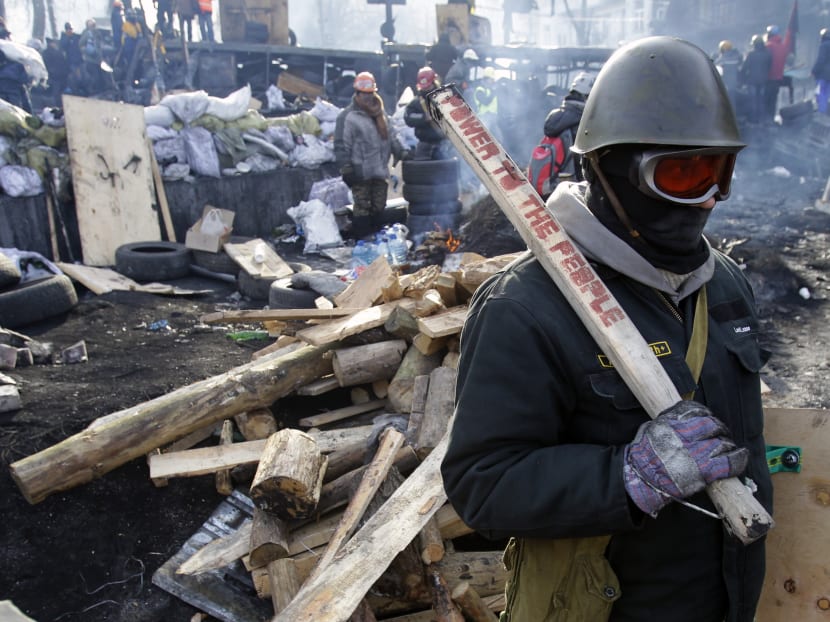 A protester guards the barricade in front of riot police in Kiev, Ukraine on Jan 27, 2014. Photo: AP