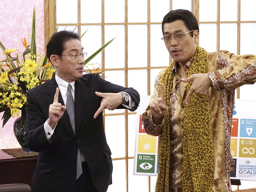 Japanese comedian Pikotaro (right) and Japan's Foreign Minister Fumio Kishida pose to raise awareness about the United Nation's 17 Sustainable Development Goals (SDGs) at the Ministry of Foreign Affairs in Tokyo on July 12, 2017. Photo: AP
