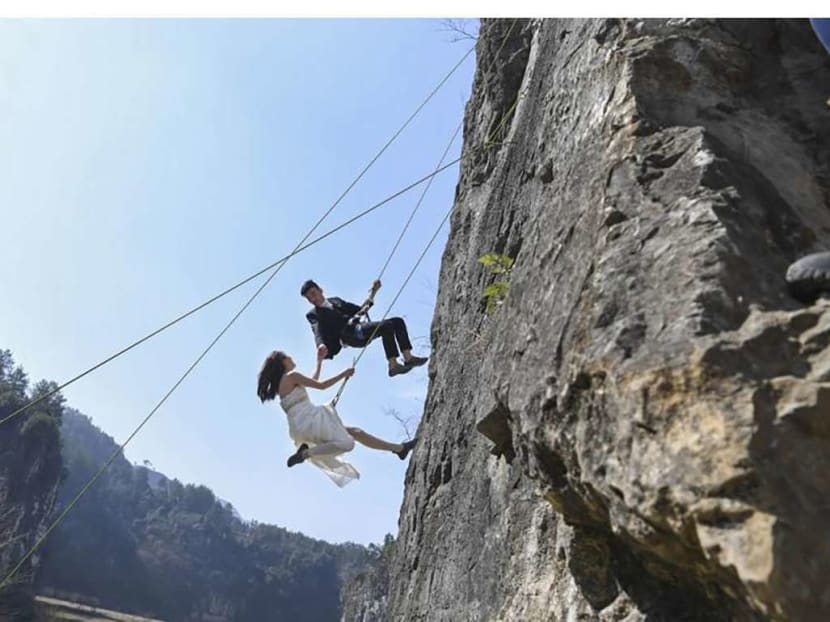 One of the couples suspended from the cliff. Photo: Chinanews.com via South China Morning Post