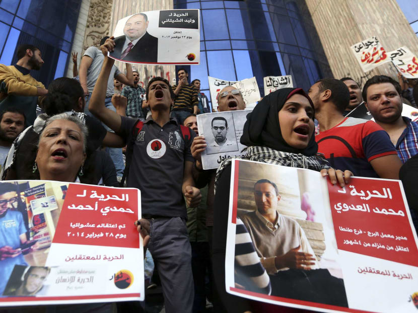 People hold posters of detainees, as they protest against a law restricting demonstrations as well as the crackdown on activists, in front of the Press Syndicate building in Cairo April 10, 2014.   Photo: Reuters
