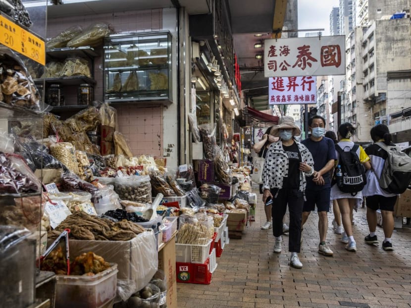 This picture taken on Nov 17, 2022 shows people walking past a shop that sells sharks fin, dried seafood and other products in Hong Kong. 
