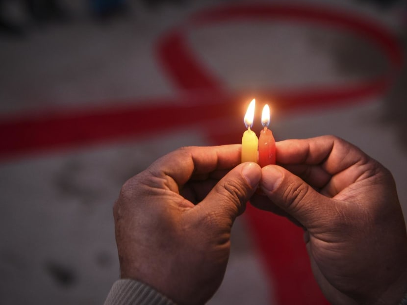 A volunteer lights candles forming the shape of a red ribbon during an awareness event on the eve of World Aids Day, in Kathmandu, Nepal, on Nov 30, 2020. A volunteer lights candles forming the shape of a red ribbon during an awareness event on the eve of World Aids Day, in Kathmandu, Nepal, on Nov 30, 2020.