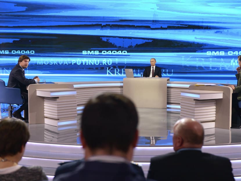 Russian President Vladimir Putin (background centre) listens during a nationally televised question-and-answer session in Moscow, April 17, 2014. Photo: AP