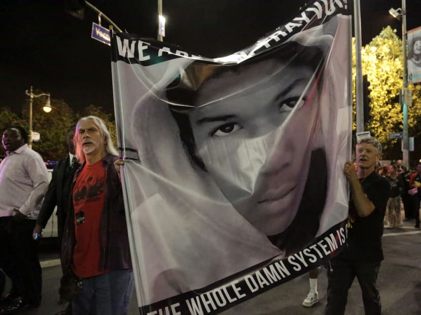 Protesters hold an image of Trayvon Martin while marching in the Leimert Park area of Los Angeles, California, following the George Zimmerman verdict, July 13, 2013. A Florida jury acquitted Zimmerman on Saturday for the shooting death of unarmed black teenager Martin, setting free a man who had become a polarizing figure in the national debate over racial profiling and self-defense laws. Reuters file photo