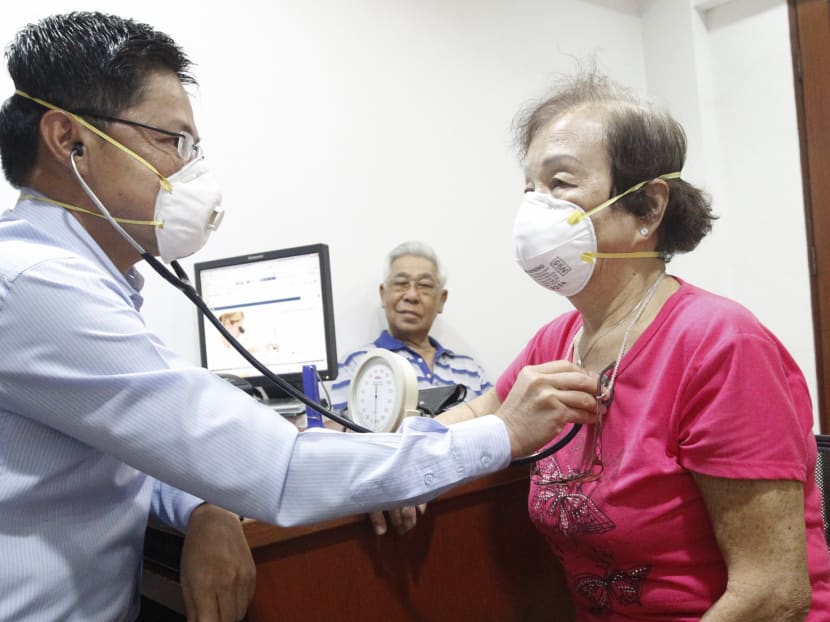 General practitioner Dr Tan with elderly patient. Photo: Ernest Chua