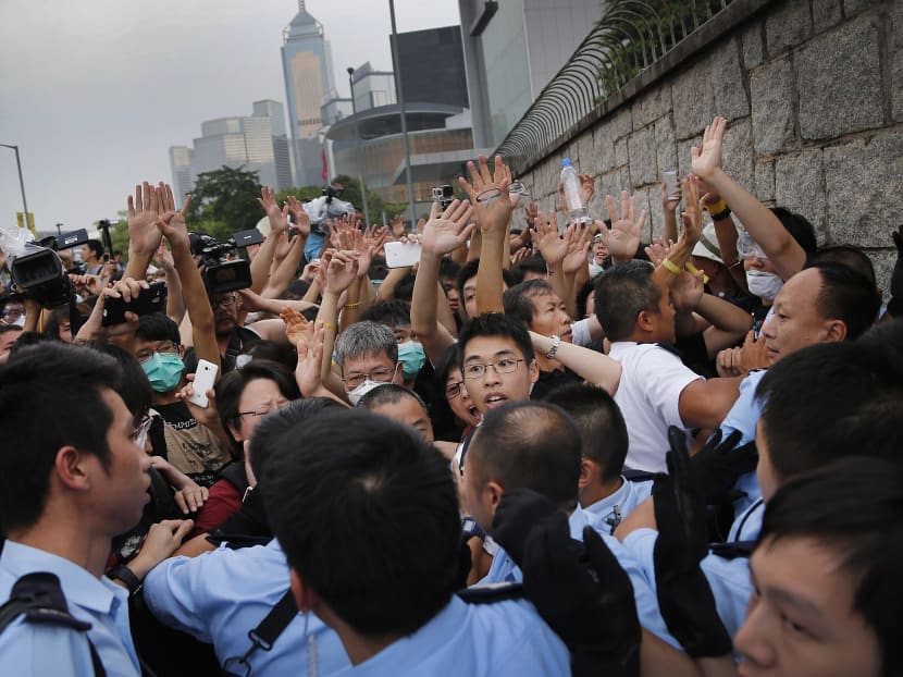 Student protesters resist during change of shift for local police but backed down after being reassured they could reoccupy the pavement outside the government compound’s gate, Thursday, Oct 2, 2014 in Hong Kong. Hong Kong police warned of serious consequences if pro-democracy protesters try to occupy government buildings, as they have threatened to do if the territory's leader doesn't resign by Thursday. Photo: AP