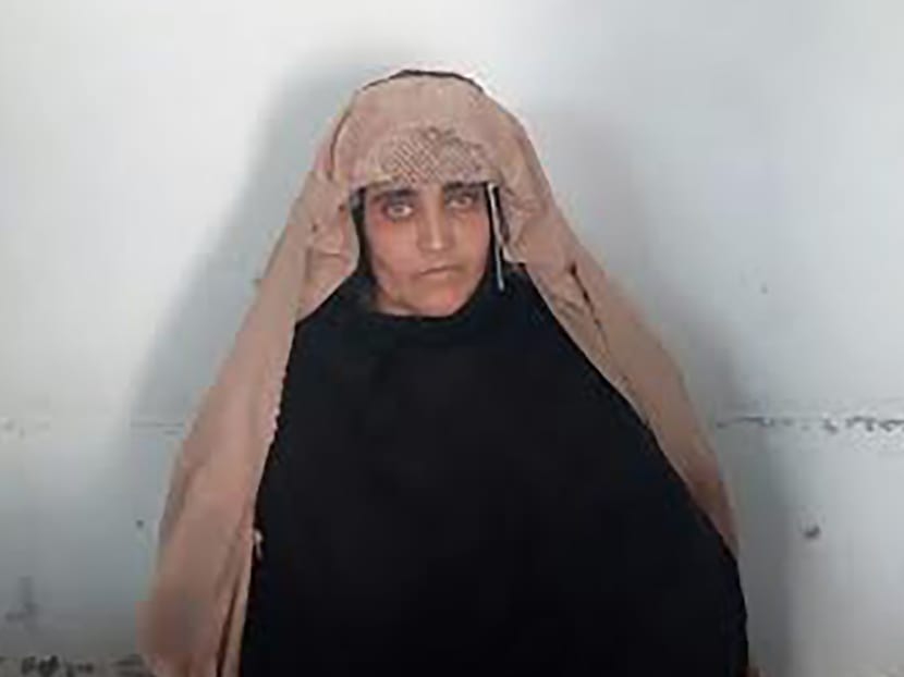 In this handout photograph released by Pakistan's Federal Investigation Agency (FIA) on Oct 26, 2016, Afghan Sharbat Gula, the 'Afghan Girl' who appeared on the cover of a 1985 edition of National Geographic magazine, waits ahead of a court hearing in Peshawar. Photo: FIA via AFP