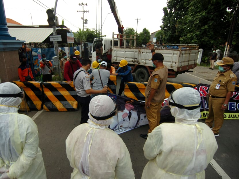 Workers set up a concrete barrier amid the spread of Covid-19 in Tegal, central Java Province, on March 29, 2020.