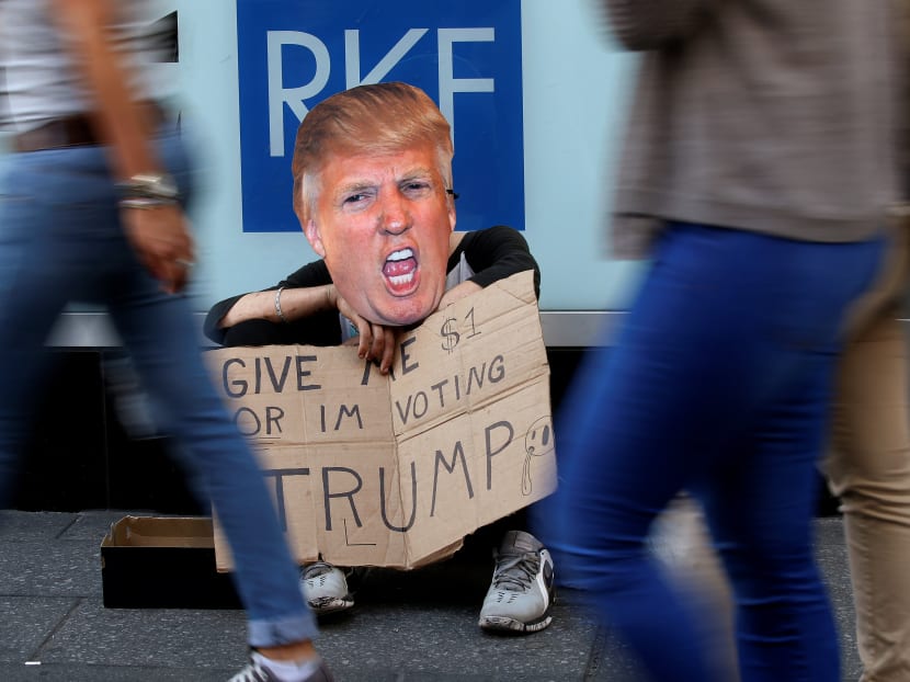 A pan handler sits with a "Give me $1 or Im voting for Trump" sign, referring to Republican presidential candidate Donald Trump, as he sits on the street in Times Square in the Manhattan borough of New York, New York, U.S., October 18, 2016.  Photo: Reuters