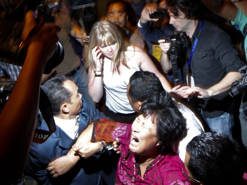 A Chinese family member of a passenger onboard the missing Malaysia Airlines Flight MH370 screams as she is being brought into a room outside the media conference area at a hotel near Kuala Lumpur International Airport, March 19, 2014. Photo: Reuters