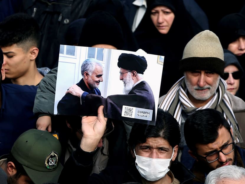 A demonstrator holding a picture of Supreme Leader Ayatollah Ali Khamenei with Iranian Major-General Qassem Soleimani, during a protest against the latter's assassination on Jan 3, 2020.