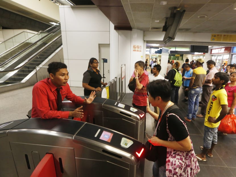 A SMRT staff advises a commuter at Boon Lay MRT station after train service on the North South East West Lines (NSEWL) was disrupted due to a power fault on 7 Jul 2015. Photo: Ooi Boon Keong/TODAY