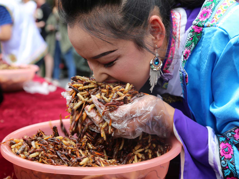 A woman participates in an insect-eating competition at a scenic spot in Lijiang, Yunnan province, China. Photo: Reuters