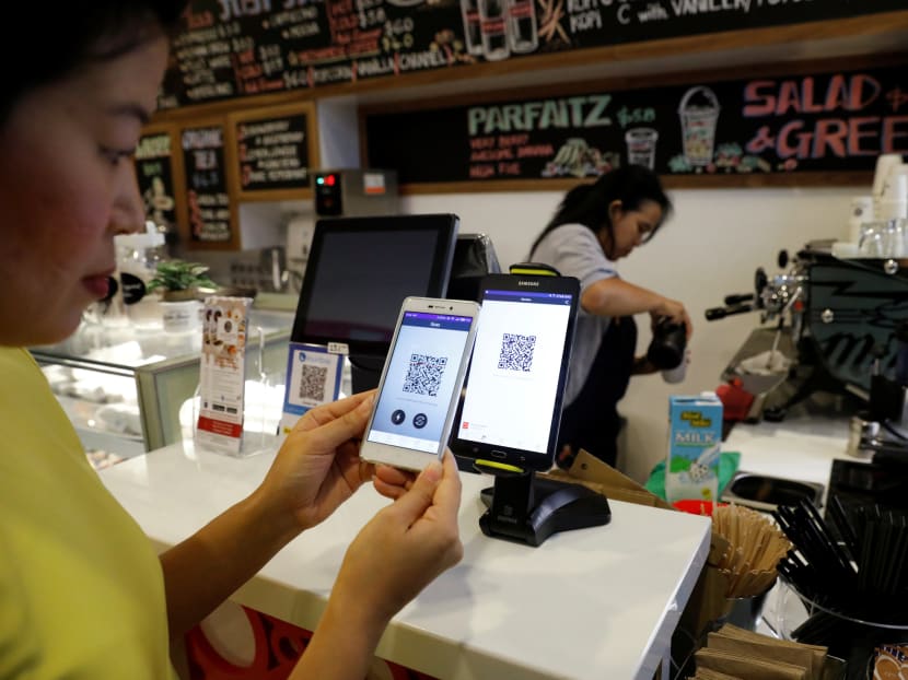 A customer paying for her coffee using a QR code at a cashless cafe in Singapore. Photo: Reuters