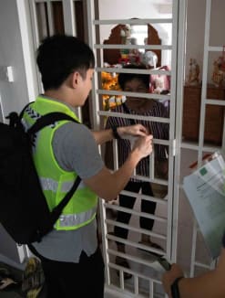 Police officers helping a resident at Block 154 Gangsa Road, while checking to see if all residents have been evacuated.