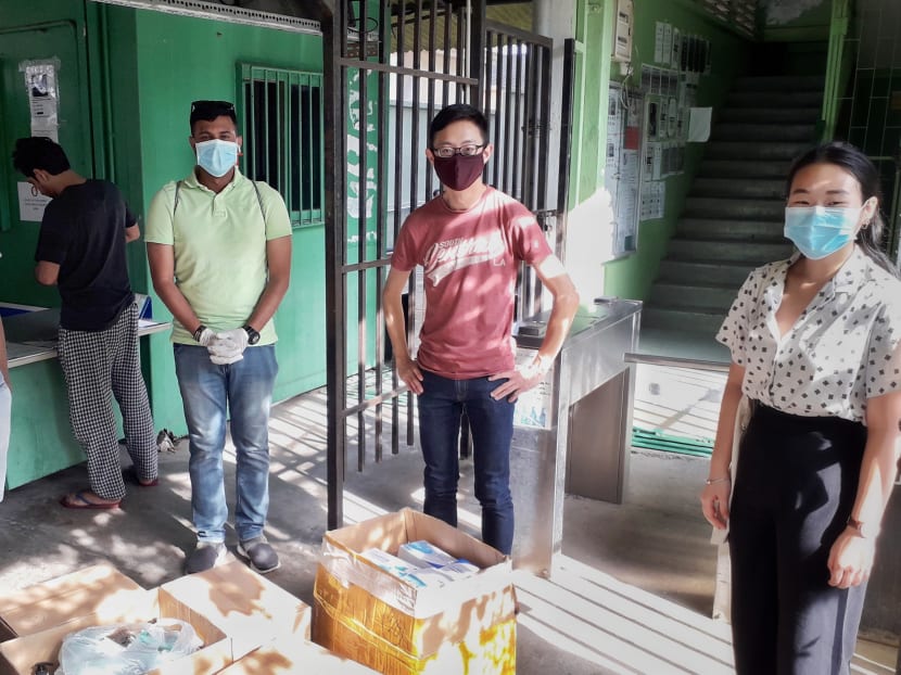 The author (centre) and fellow volunteers delivering hand sanitisers and masks to migrant workers staying in a factory-converted dormitory in April 2020.