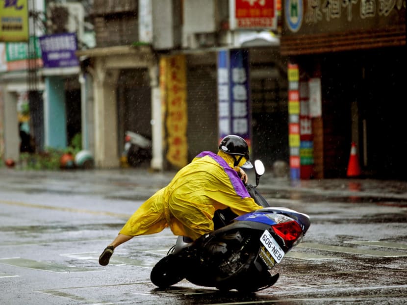 A motorcyclist losing his balance as the powerful Typhoon Megi hit Hualien in eastern Taiwan. In Taipei, bus services and overground train services were also cancelled. PHOTO: REUTERS
