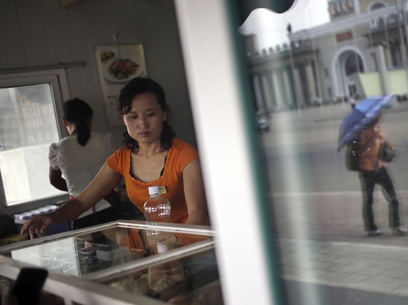 In this Aug 21, 2015 photo, food vendors serve customers at a kiosk in Pyongyang, North Korea. Photo: AP