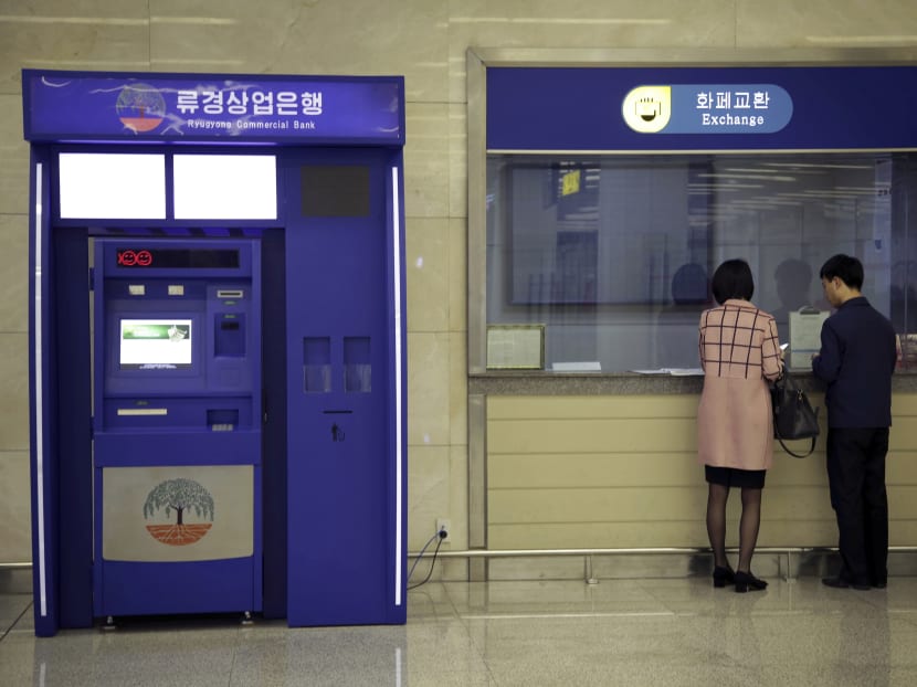 In this Tuesday, April 11, 2017, photo, a man and woman stand at a counter next to a Ryugyong Commercial Bank automated teller machine at the Sunan International Airport in Pyongyang, North Korea. Photo: AP