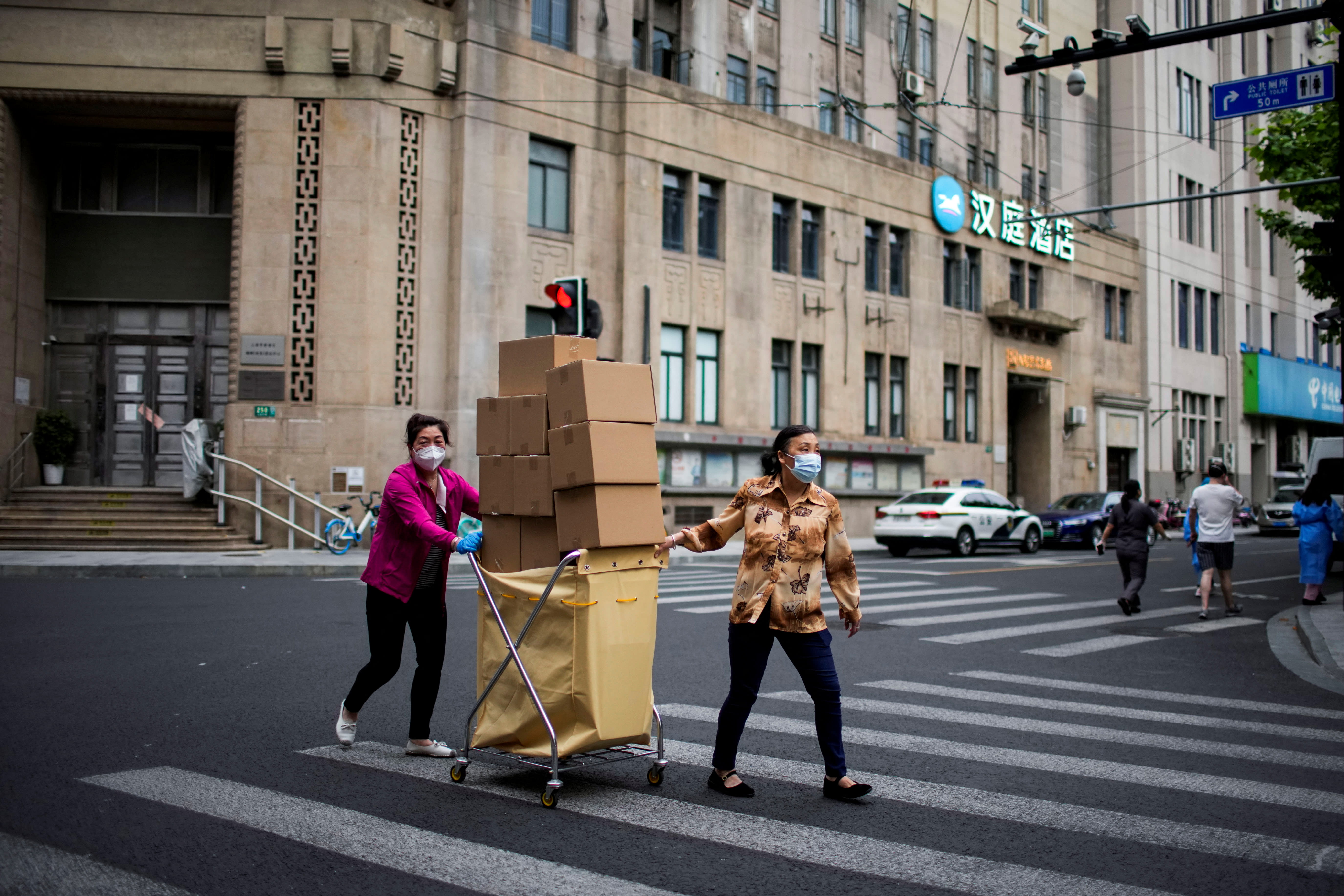 Women carry boxes of food on a street during lockdown, amid the Covid-19 outbreak, in Shanghai, China on May 18, 2022. 