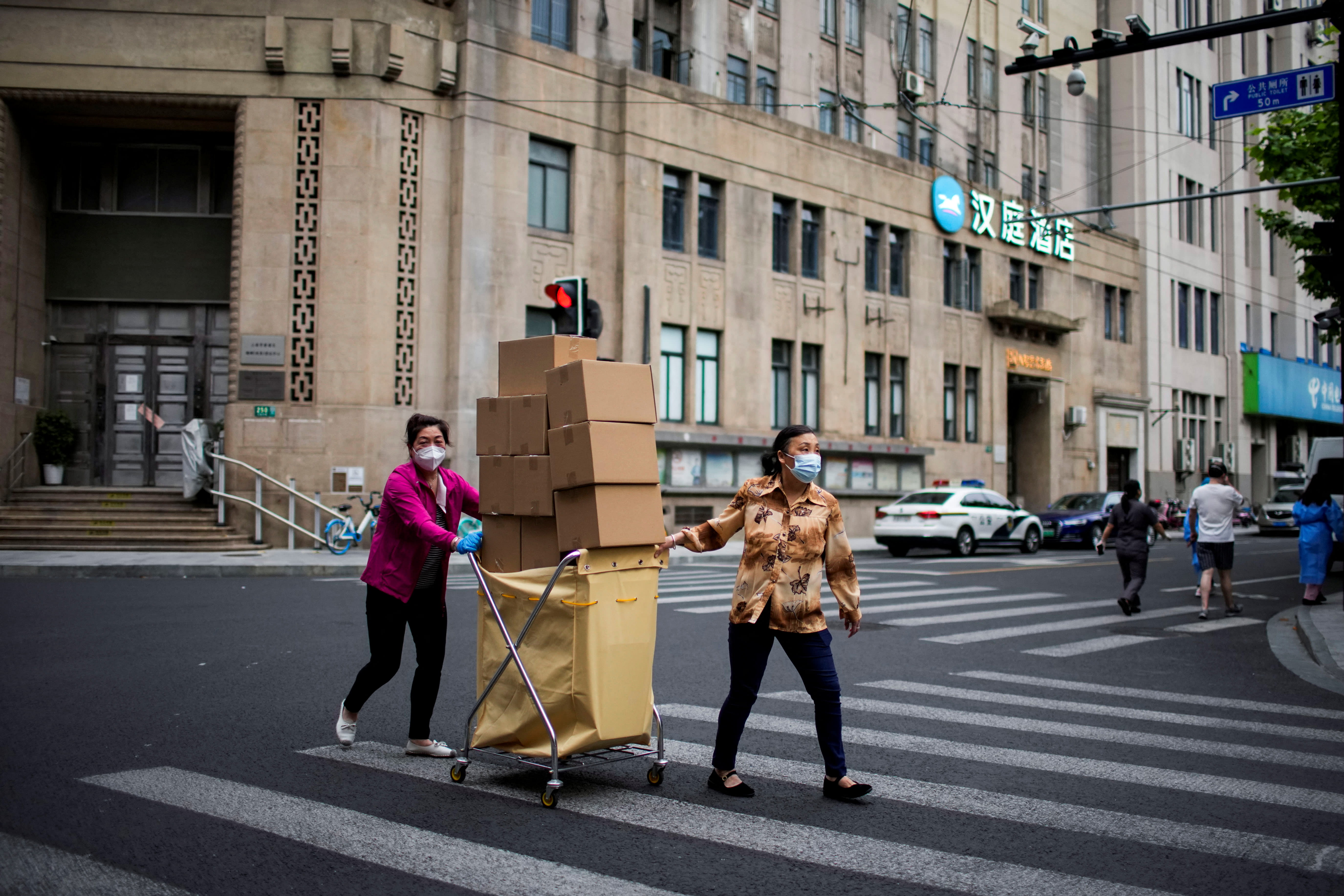 Women carry boxes of food on a street during lockdown, amid the Covid-19 outbreak, in Shanghai, China on May 18, 2022. Women carry boxes of food on a street during lockdown, amid the Covid-19 outbreak, in Shanghai, China on May 18, 2022.