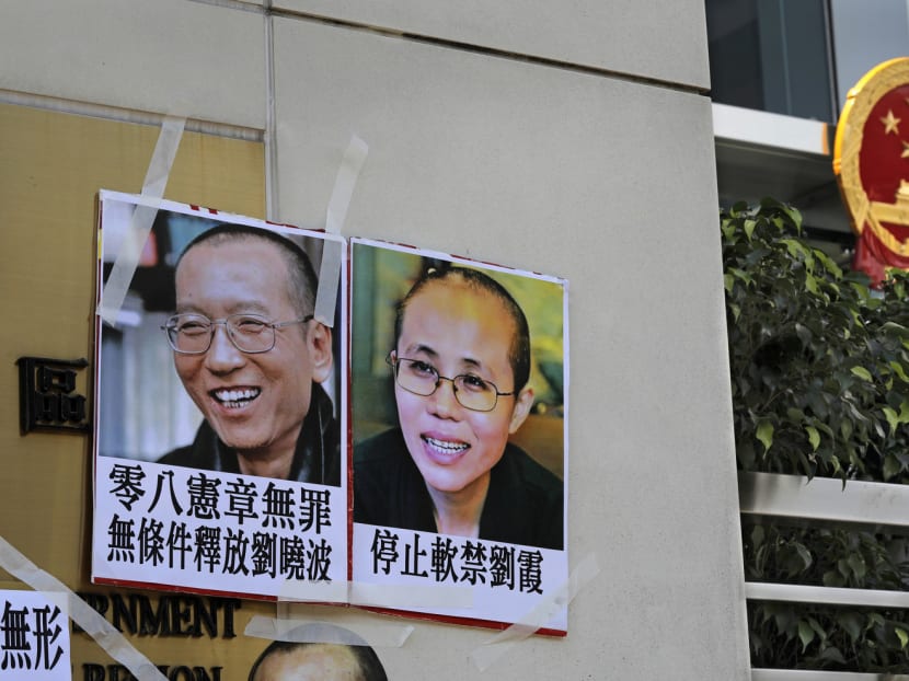 Protesters display portrait of jailed Chinese Nobel Peace laureate Liu Xiaobo and his detained wife Liu Xia during a demonstration outside the Chinese liaison office in Hong Kong. Photo: AP