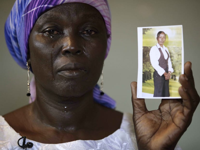 In this May 2014 file photo, Martha Mark, the mother of kidnapped school girl Monica Mark cries as she displays her photo, in the family house, in Chibok, Nigeria.  Photo: AP