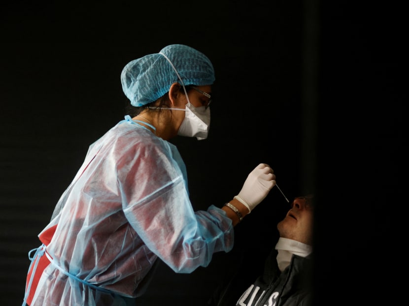 A medical worker, wearing a protective suit and a face mask, performs a rapid Covid-19 antigenic test on a patient in a Covid-19 testing centre in Sautron near Nantes, France on Dec 7, 2020.