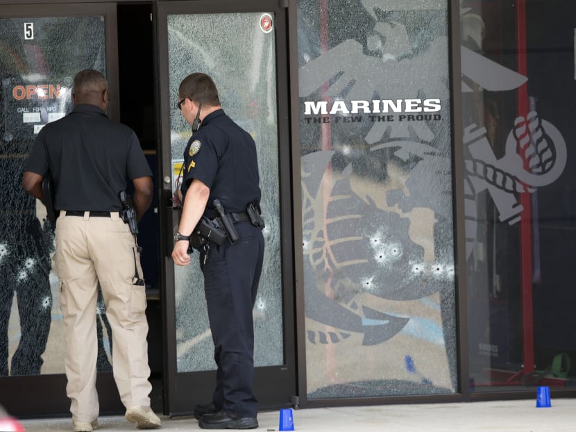 Police officers enter the Armed Forces Career Center through a bullet-riddled door after a gunman opened fire on the building Thursday, July 16, 2015, in Chattanooga, Tenn. Authorities say there were multiple casualties including the gunman. Photo: AP